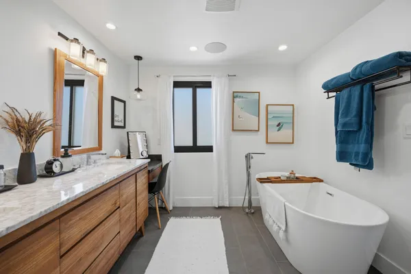 a spacious bathroom with a double vanity sink a mirror and a bathtub