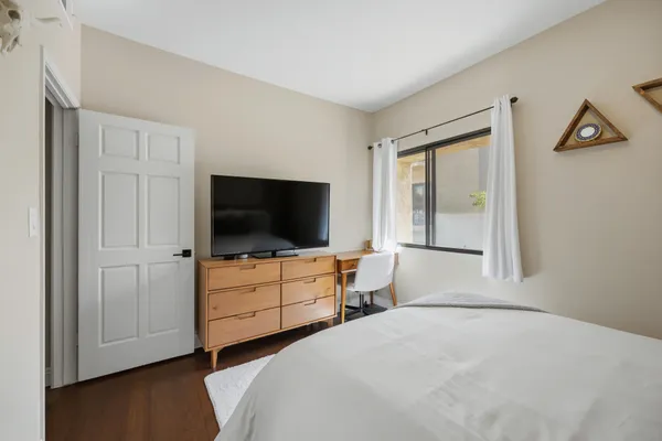 a bedroom with a bed and a flat screen tv