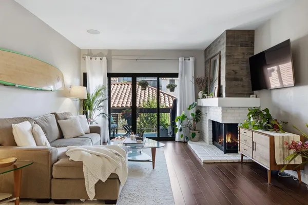 a living room with furniture a fireplace and a flat screen tv