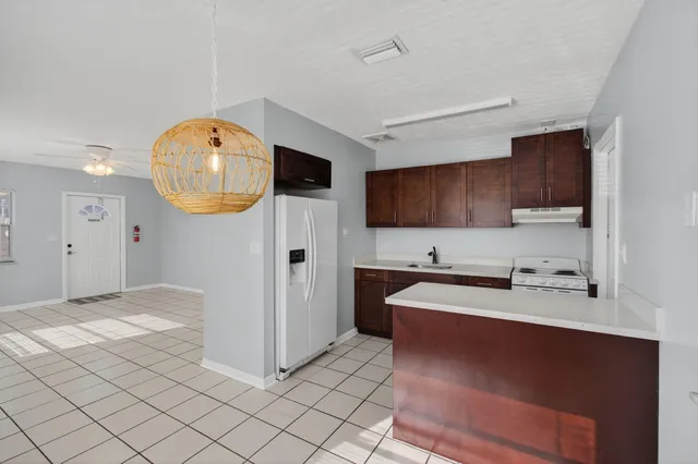 a kitchen with stainless steel appliances a stove a sink a microwave a refrigerator and cabinets