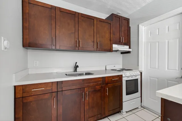 a kitchen with stainless steel appliances granite countertop a sink stove and cabinets
