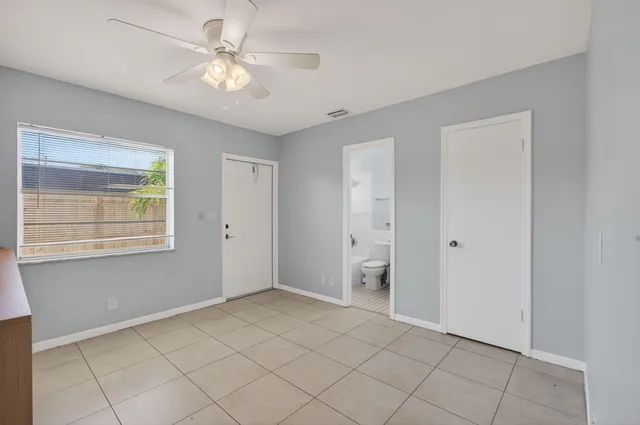 a view of an empty room with window and cabinet