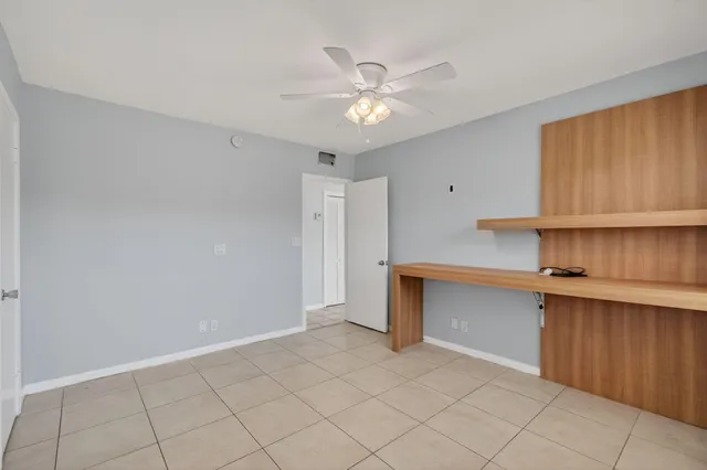 a view of an empty room with window and cabinet