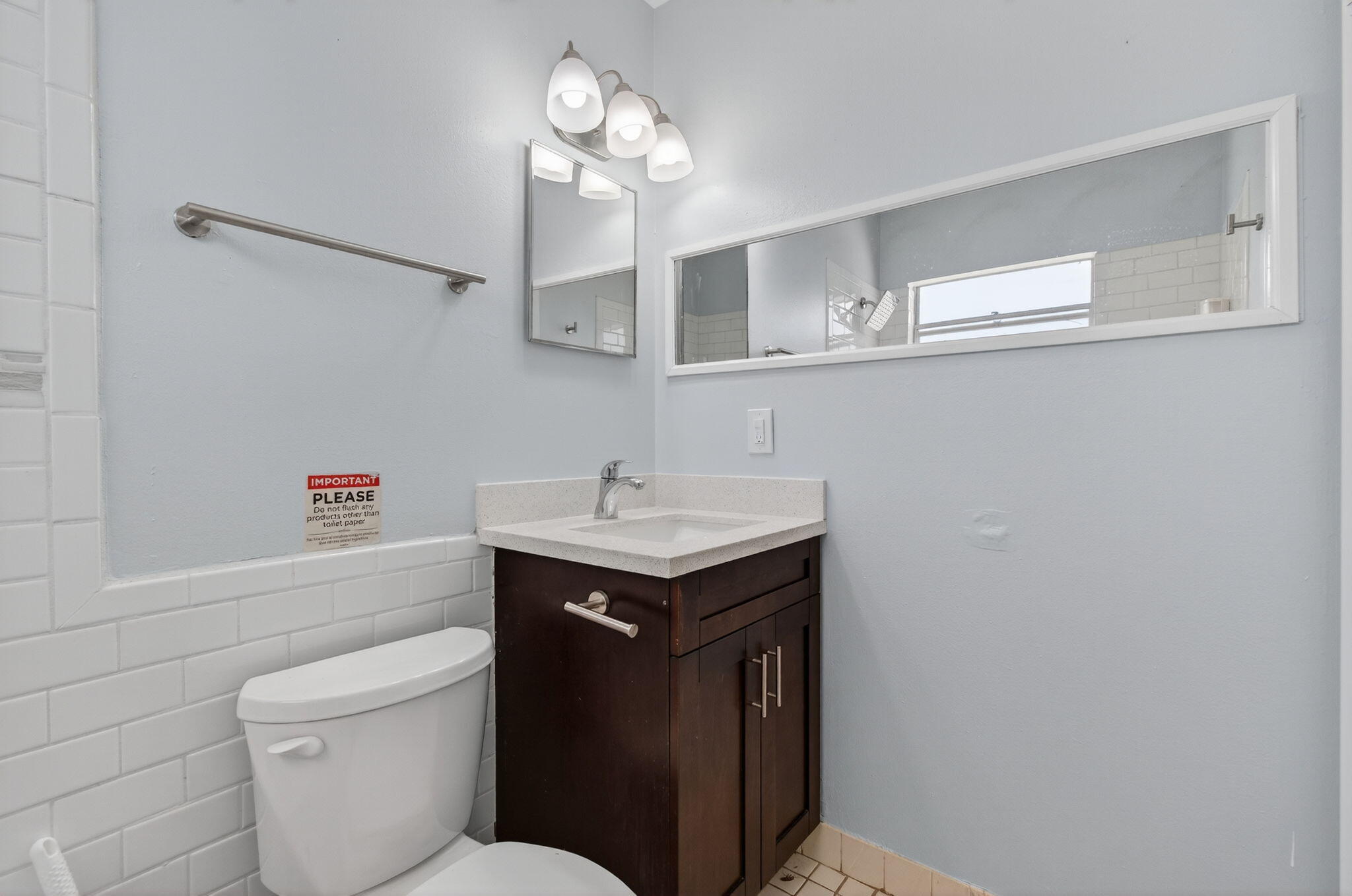 109 Southeast 11th Avenue, Unit 13 Pompano Beach, FL 33060 - Photo 18 of 37 a bathroom with a sink a toilet and a mirror