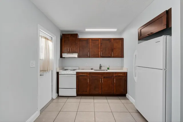 a kitchen with a refrigerator sink and cabinets