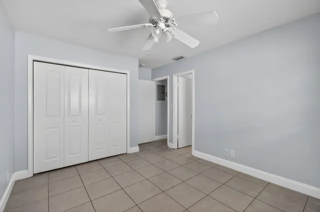 a view of an empty room and chandelier fan