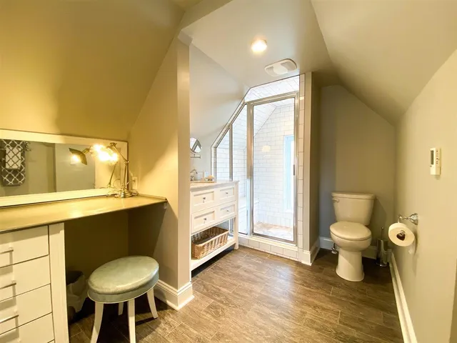 a bathroom with a granite countertop toilet sink and mirror
