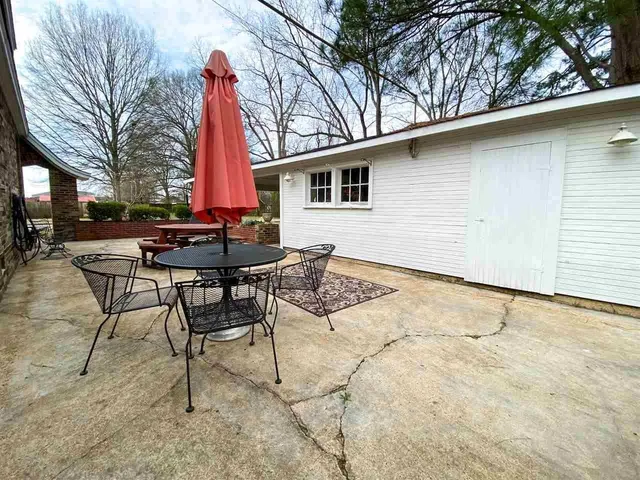 a backyard of a house with table and chairs