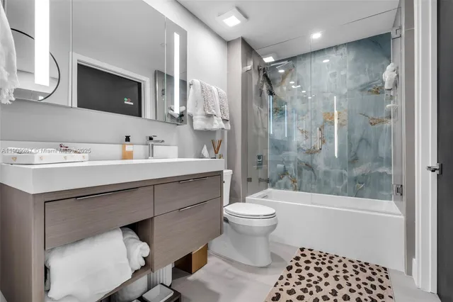 a bathroom with a toilet sink vanity tub and shower