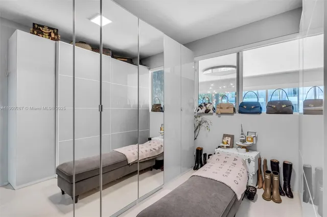 a bedroom with a bed window and a flat screen tv