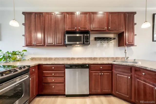 a kitchen with granite countertop wooden cabinets stainless steel appliances and a sink