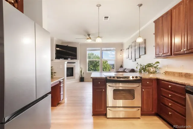 a kitchen with stainless steel appliances granite countertop a sink a stove and a microwave