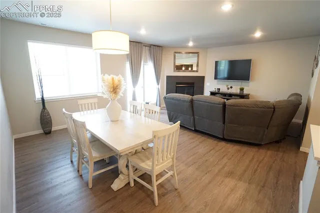 a living room with furniture a flat screen tv and a wooden floor