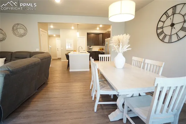 a living room with furniture a table and kitchen chandelier