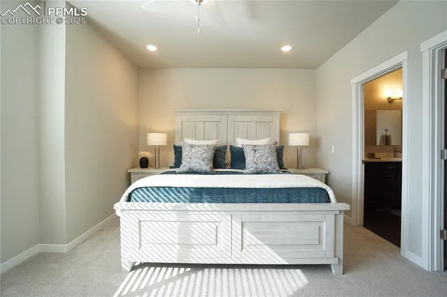 a spacious bedroom with a bed and a lamp