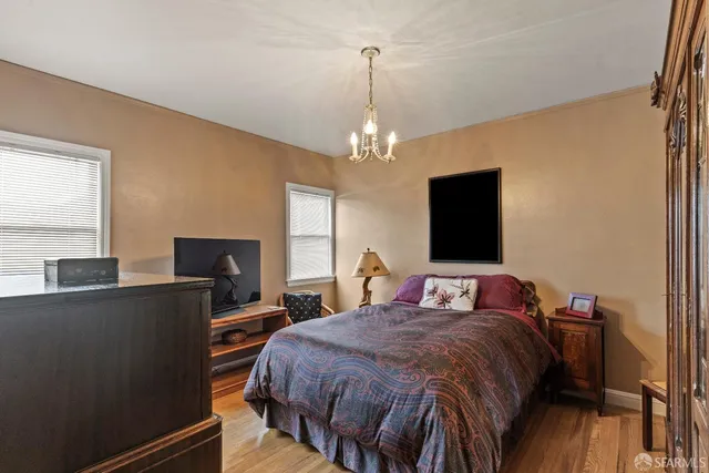 a bedroom with a bed and a flat tv screen on dresser