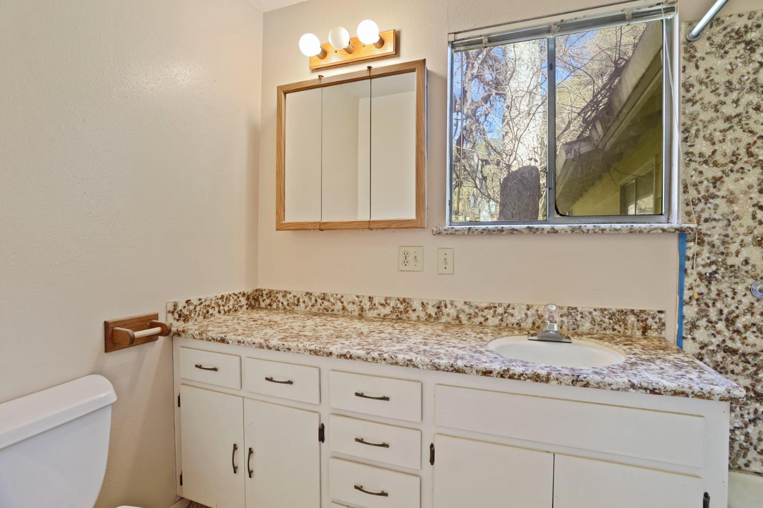 20200 Tuolumne Road North Tuolumne, CA 95379 - Photo 42 of 43 a bathroom with a granite countertop sink and a mirror