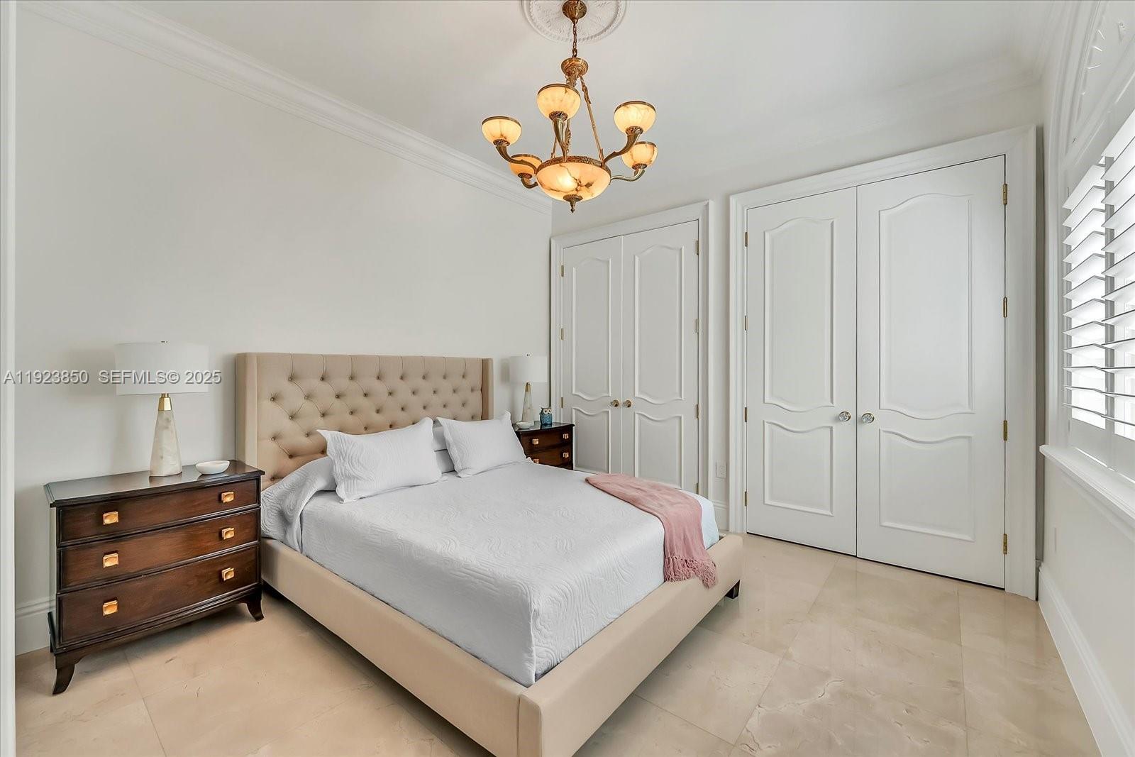 18611 Southwest 122nd Street Miami, FL 33196 - Photo 31 of 55 a bedroom with a bed and a chandelier