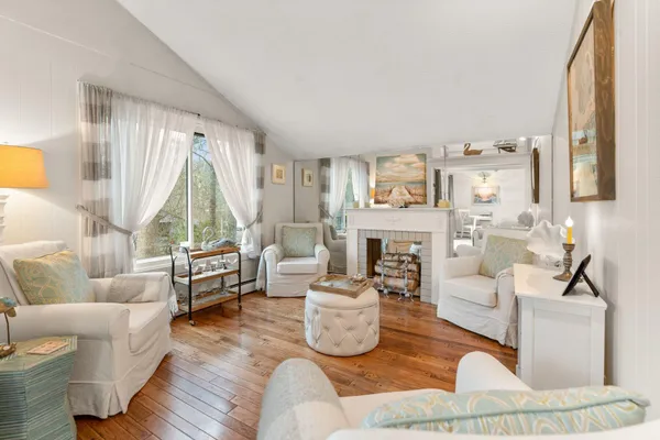 a living room with furniture a fireplace and a large window