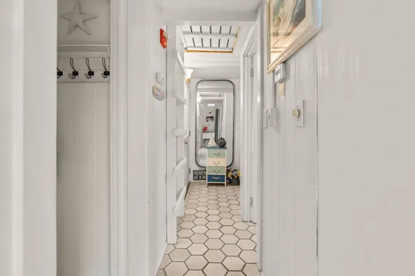 a hallway with a door and a bathroom