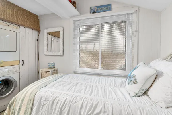 a bedroom with a bed and a large window
