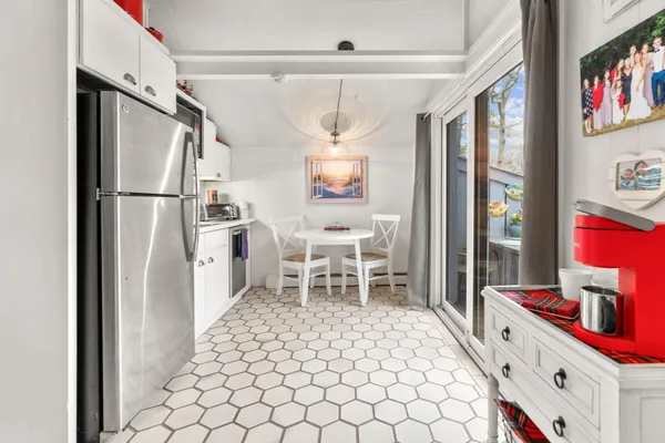 a kitchen with a refrigerator and table chair