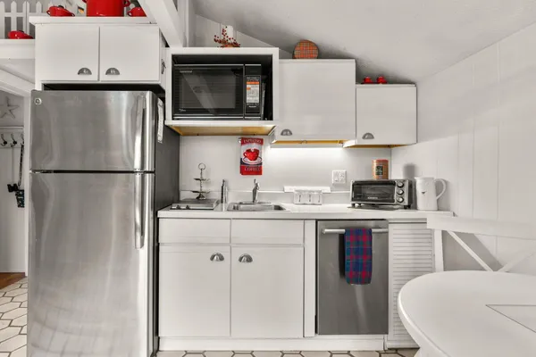 a kitchen with stainless steel appliances granite countertop a refrigerator sink stove and white cabinets