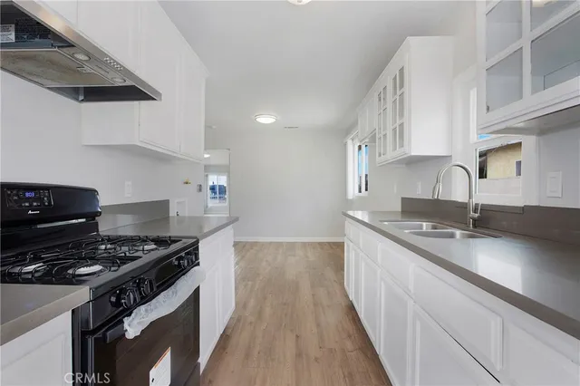 a kitchen with granite countertop a sink stove and cabinets