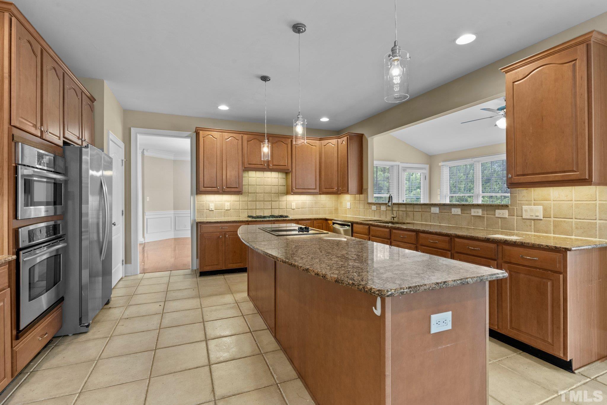9501 Bluemont Court Raleigh, NC 27617 - Photo 46 of 85 a kitchen with stainless steel appliances granite countertop a sink stove and refrigerator