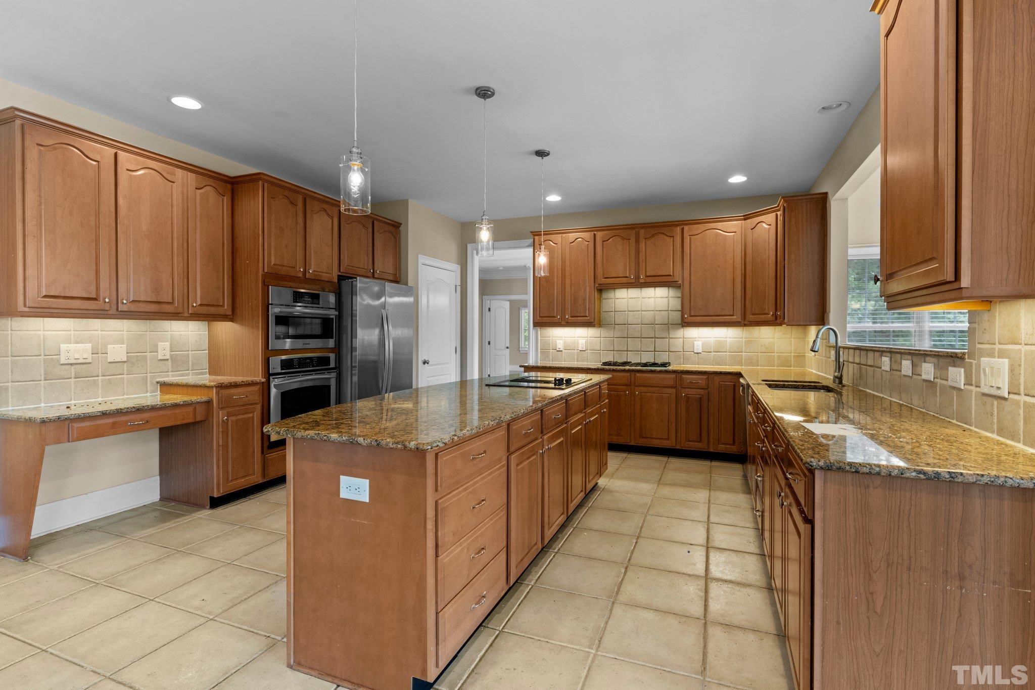 9501 Bluemont Court Raleigh, NC 27617 - Photo 47 of 85 a kitchen with stainless steel appliances granite countertop a sink counter space cabinets and a large window