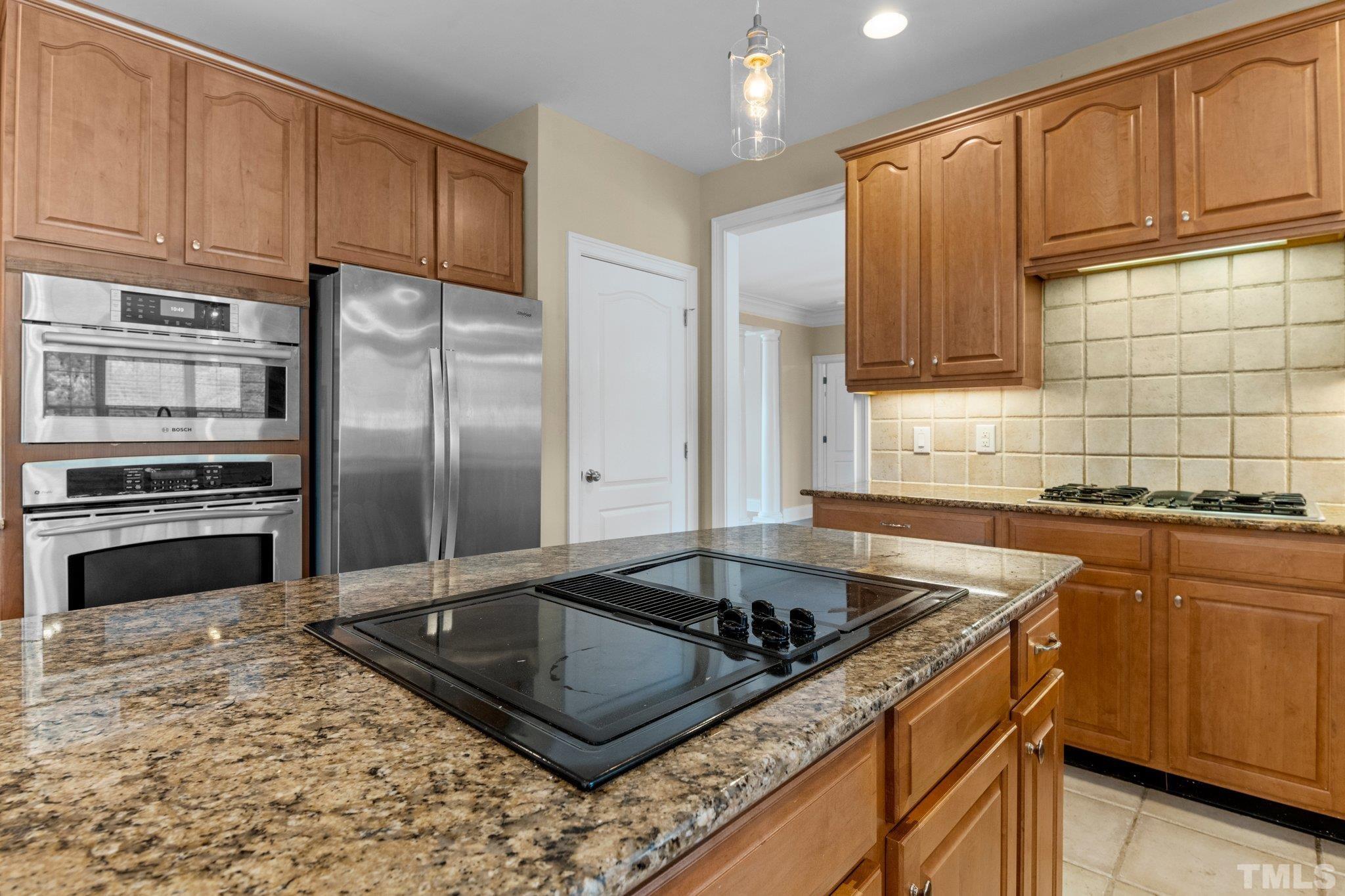 9501 Bluemont Court Raleigh, NC 27617 - Photo 48 of 85 a kitchen with stainless steel appliances granite countertop a sink stove and refrigerator
