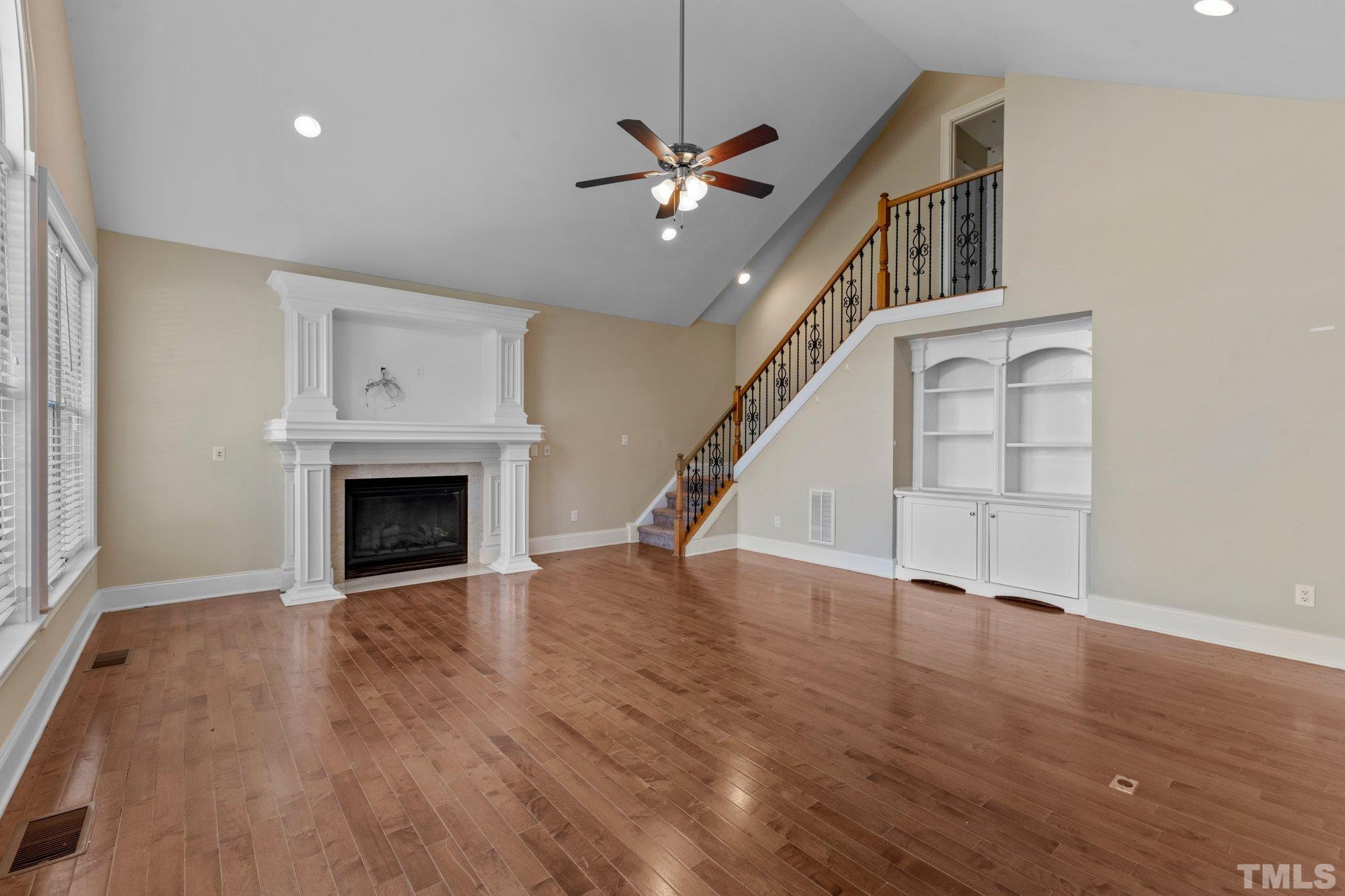 9501 Bluemont Court Raleigh, NC 27617 - Photo 50 of 85 a view of an empty room with wooden floor fireplace and a window