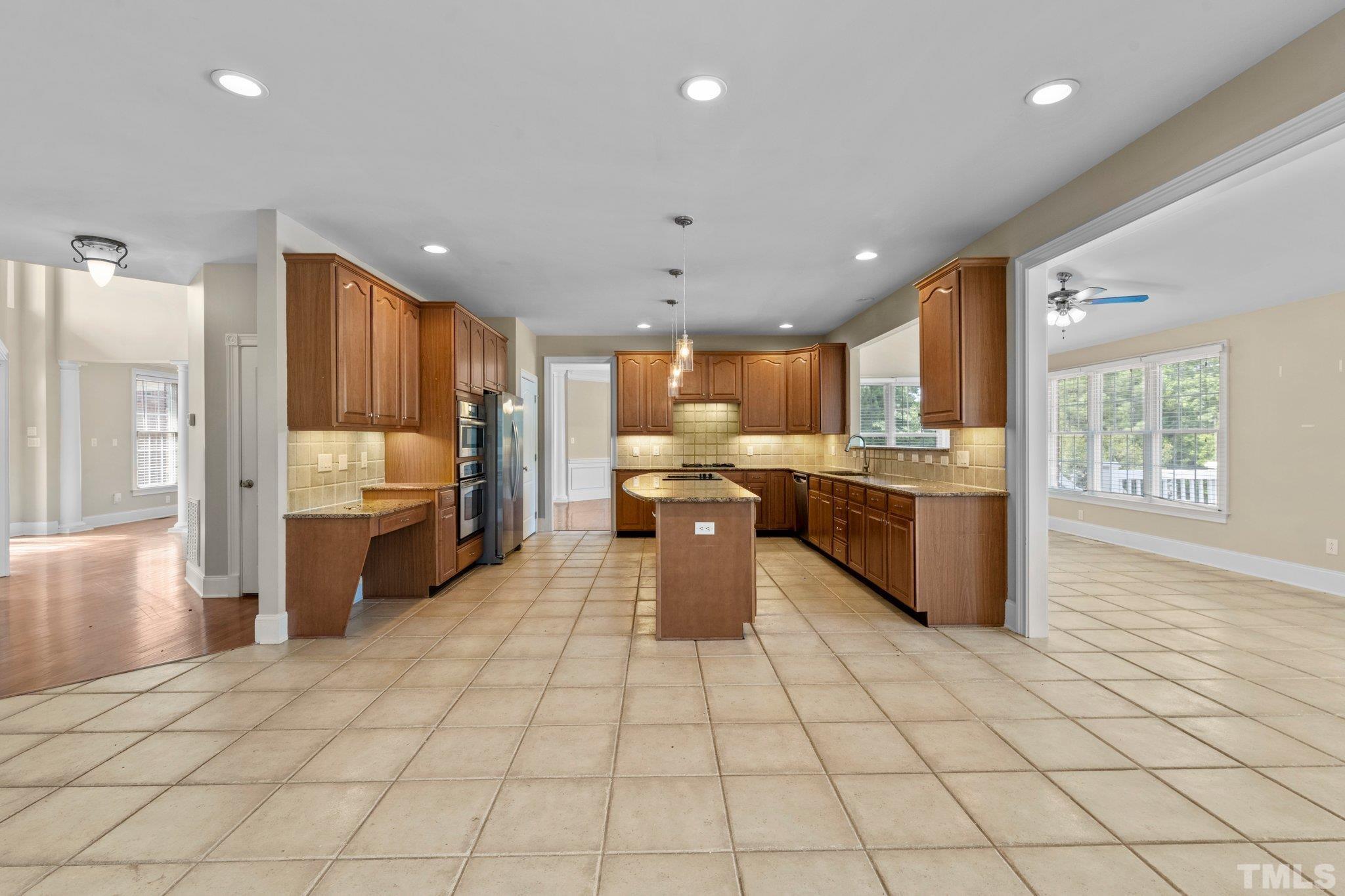 9501 Bluemont Court Raleigh, NC 27617 - Photo 51 of 85 a kitchen with stainless steel appliances a sink a stove a refrigerator cabinets and a window
