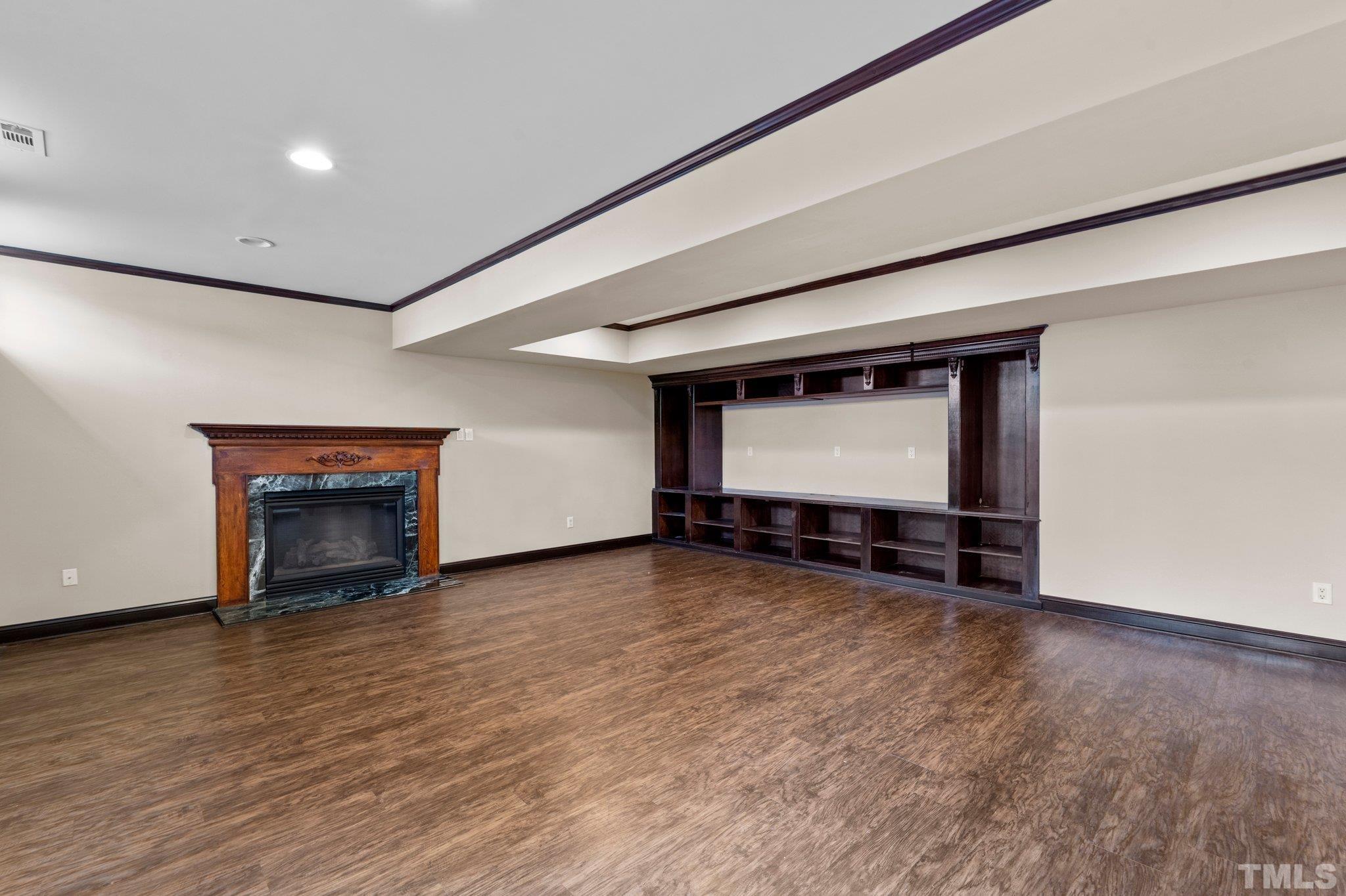 9501 Bluemont Court Raleigh, NC 27617 - Photo 67 of 85 a view of an empty room with wooden floor fireplace and a window