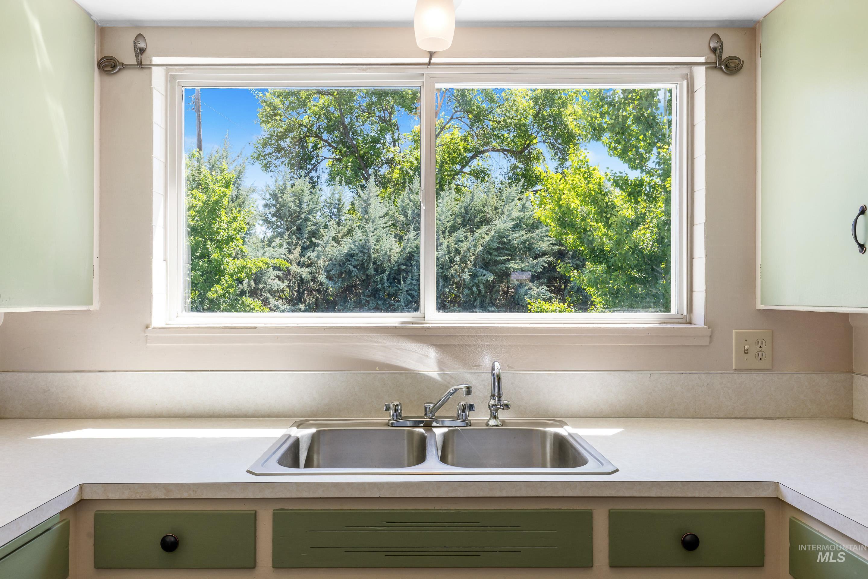 708 South Phillippi Street Boise, ID 83705 - Photo 11 of 25 Kitchen sink area featuring a dual-basin stainless steel sink, chrome faucet, and light-toned countertops