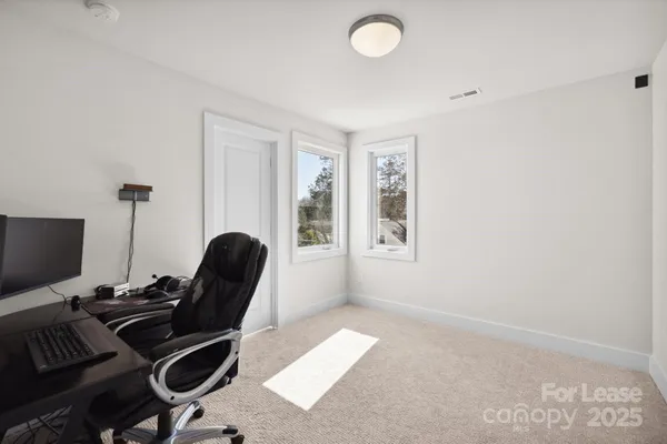 a view of a workspace with furniture and a window