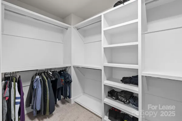 a view of walk in closet with clothes and shoes