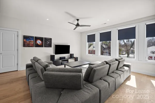 a living room with furniture a ceiling fan and a flat screen tv