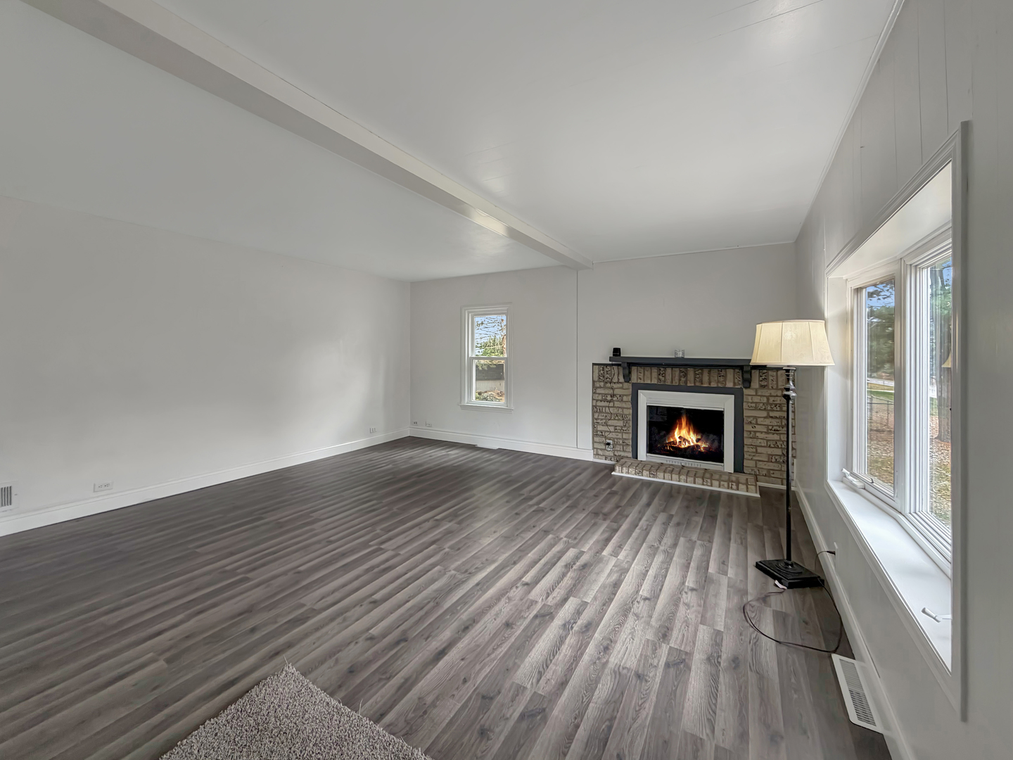 1534 West Fairview Road Freeport, IL 61032 - Photo 5 of 30 an empty room with wooden floor fireplace and windows