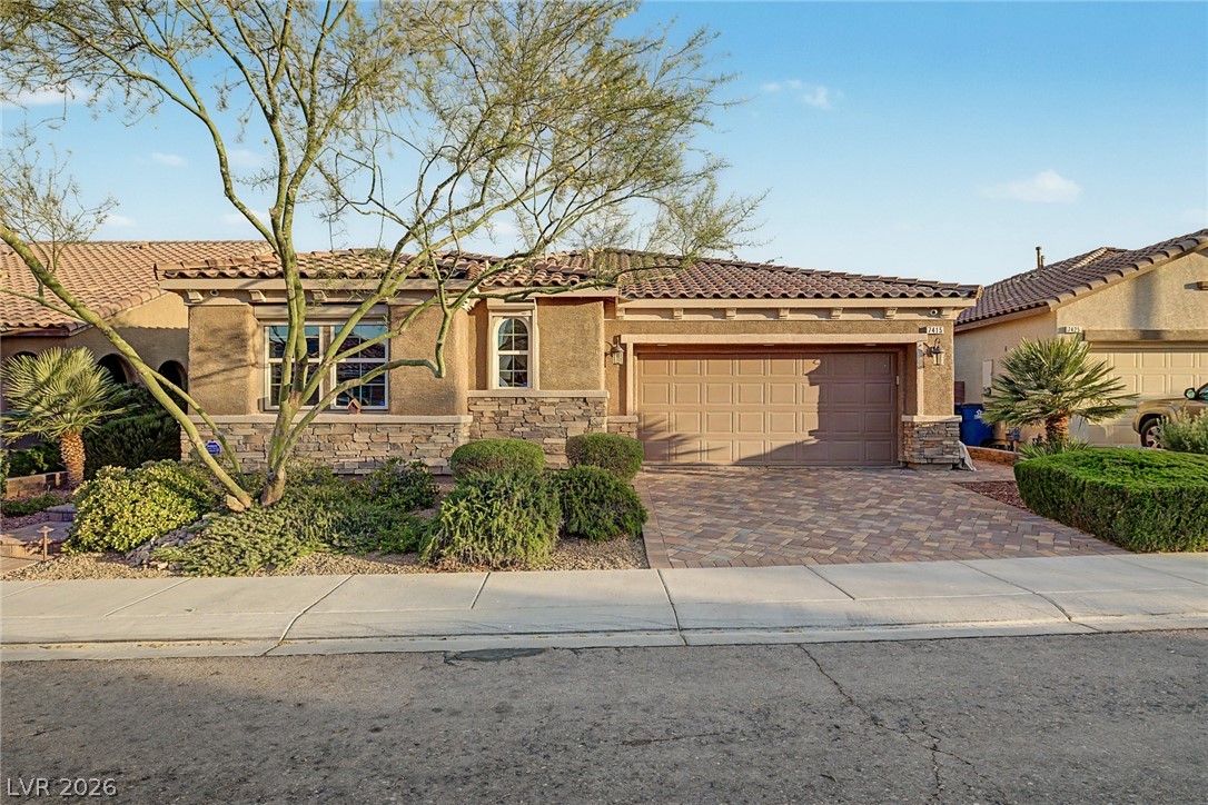 7415 Campbell Ranch Avenue Las Vegas, NV 89179 - Photo 8 of 52 A well-maintained facade features an attached garage and desert landscaping.