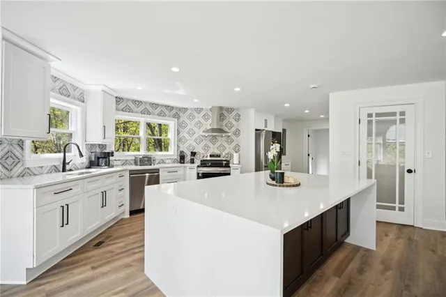 a large kitchen with stainless steel appliances lots of counter top space