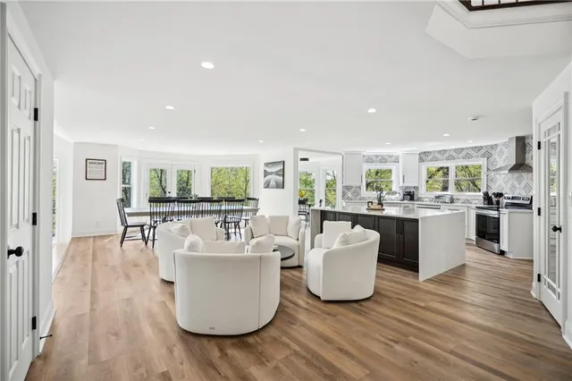 a living room with furniture a wooden floor and white walls