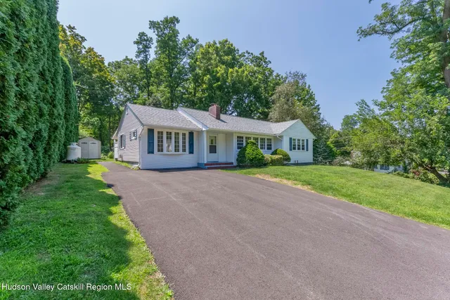 a front view of a house with yard and green space