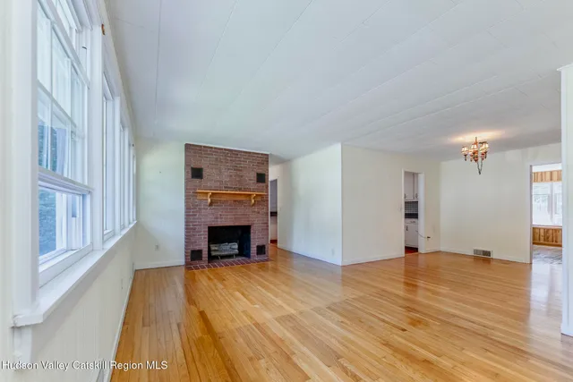 a view of an empty room with a fireplace and a window