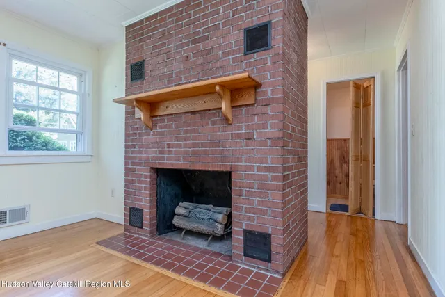 a living room with a fireplace and wooden floor
