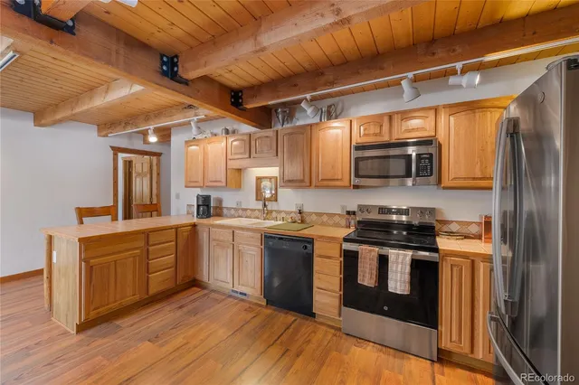 a kitchen with stainless steel appliances granite countertop a stove a sink dishwasher and a refrigerator