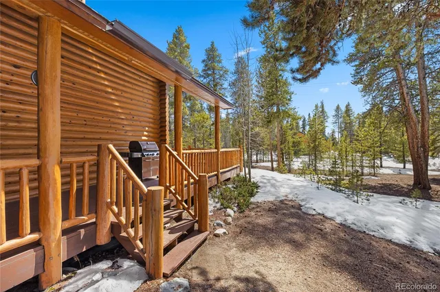 a view of a house with a yard and large tree