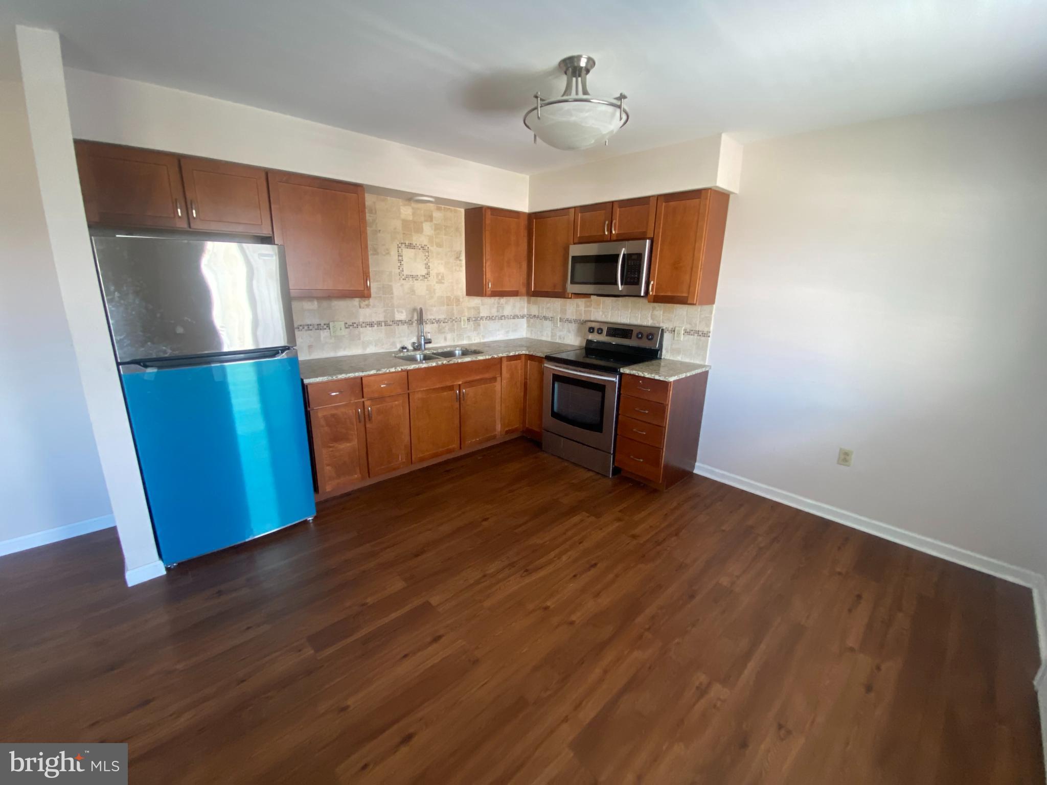427 Smith Street, Unit 2R Dunmore, PA 18512 - Photo 2 of 7 a kitchen with stainless steel appliances granite countertop a refrigerator a sink dishwasher a stove with wooden floors