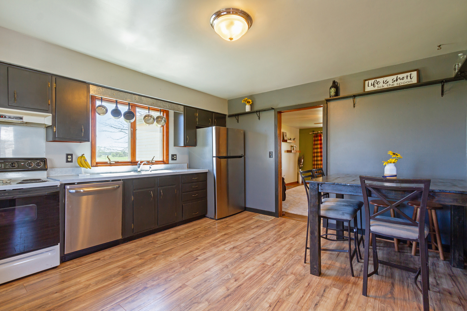 4783 Cherry Valley Road Kirkland, IL 60146 - Photo 10 of 41 a kitchen with stainless steel appliances granite countertop wooden floors a stove and a refrigerator