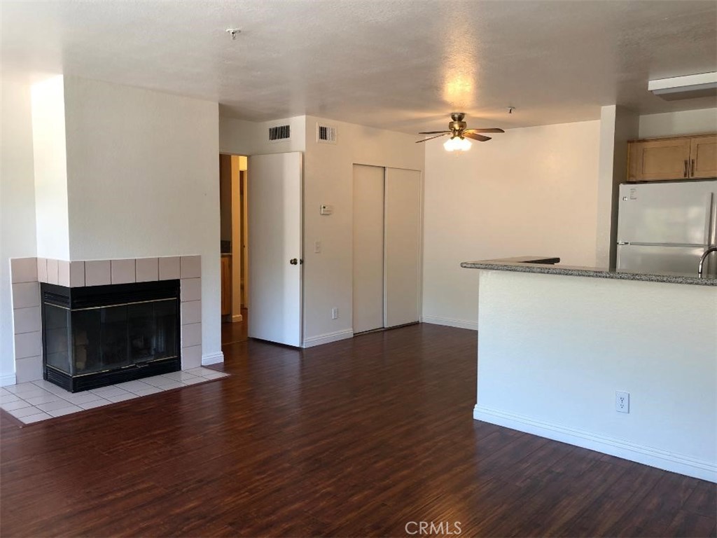 12584 Atwood Court, Unit 1824 Rancho Cucamonga, CA 91739 - Photo 5 of 15 a view of a kitchen with wooden floor and a fireplace